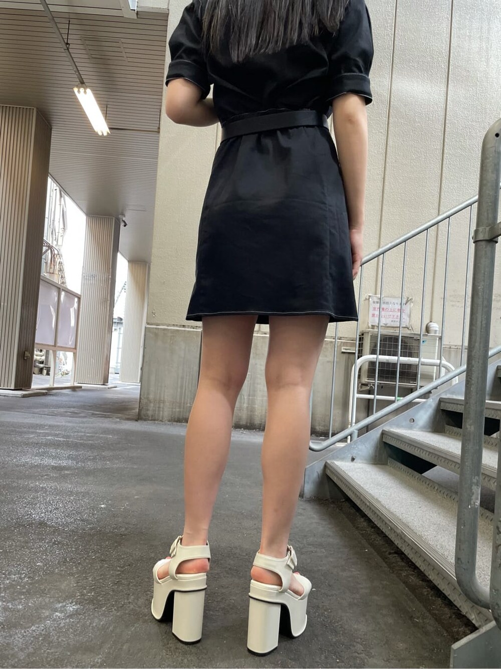 ブラック系のワンピース、ゴールド系のピアス（両耳用）を着用したレディースの夏コーディネートの3枚目の写真