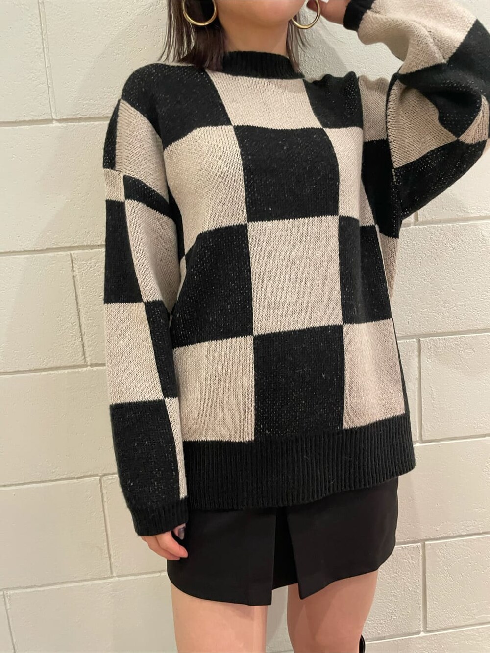 ブラック系のブーツ、ブラック系のスカート、ブラック系のニット/セーターを着用したレディースの冬コーディネートの4枚目の写真