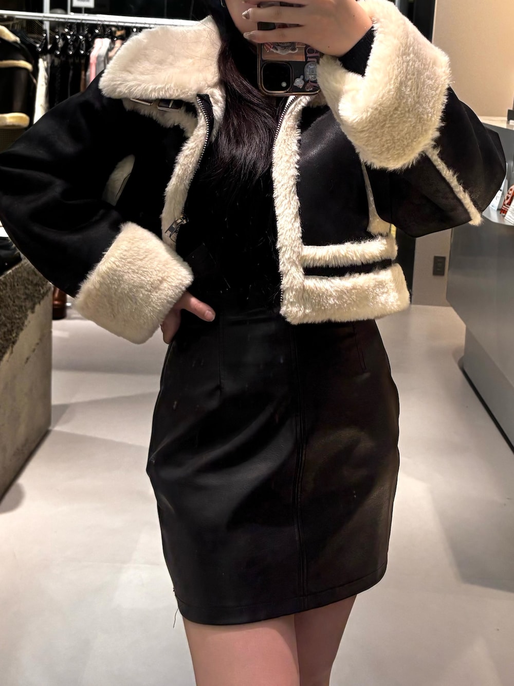 ブラック系のブルゾン、ブラック系のニット/セーター、ホワイト系のブーツを着用したレディースの冬コーディネートの4枚目の写真