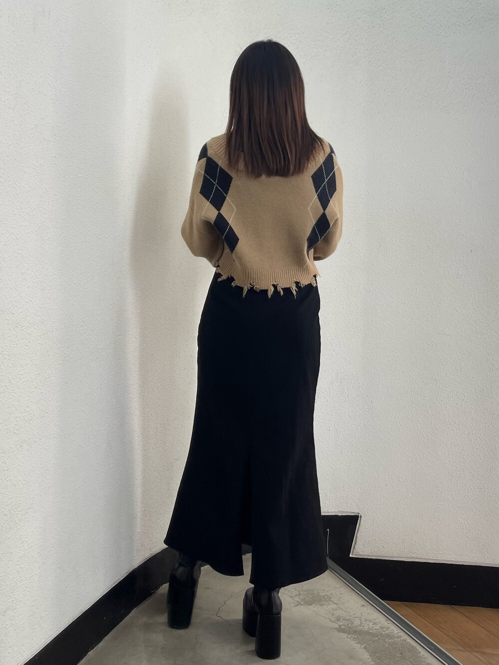 ブラック系のスカート、ブラック系のブーツ、その他のニット/セーターを着用したレディースの秋コーディネートの3枚目の写真