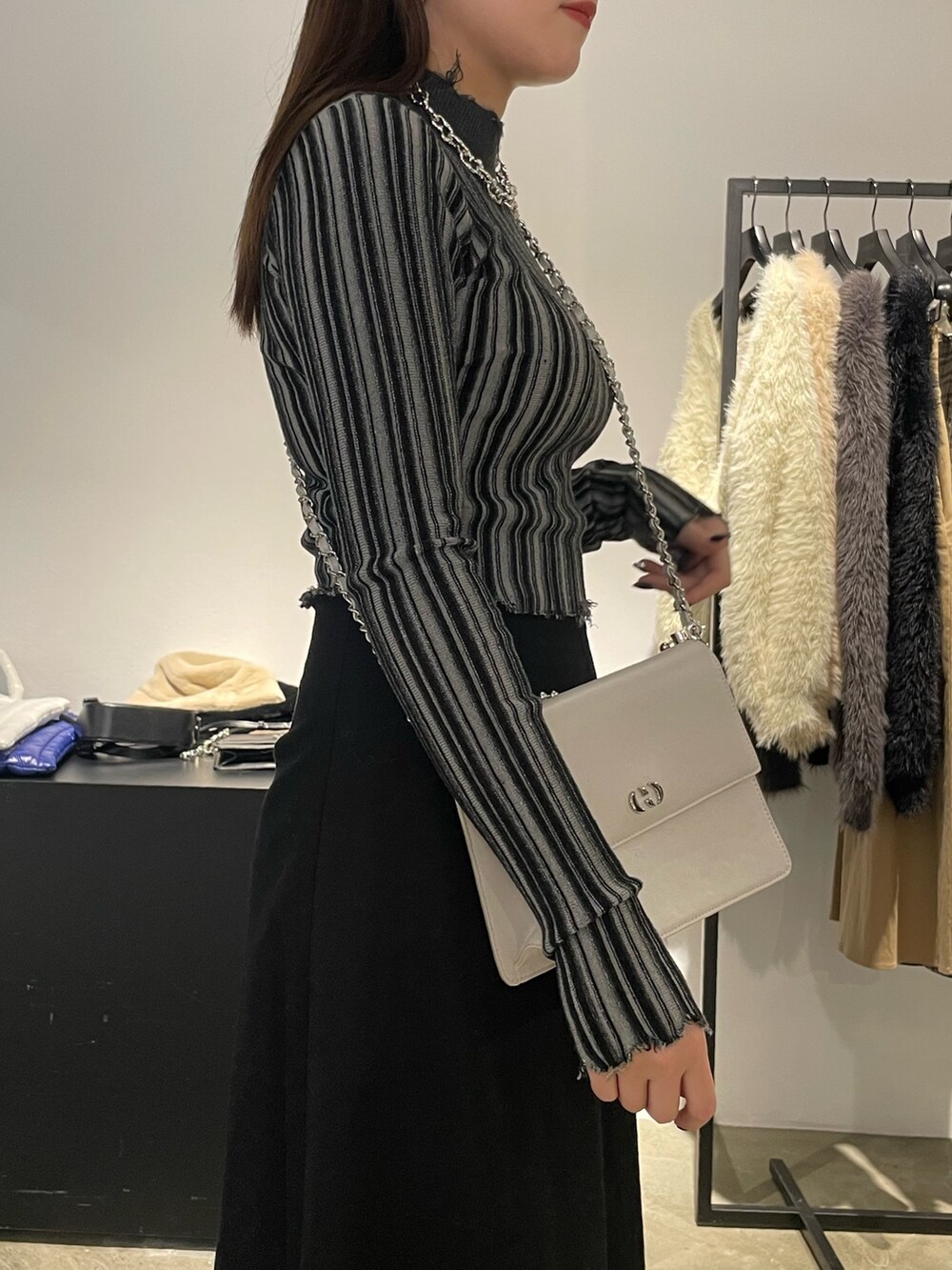 ブラック系のスカート、ブラック系のブーツ、その他のニット/セーターを着用したレディースの冬コーディネートの4枚目の写真