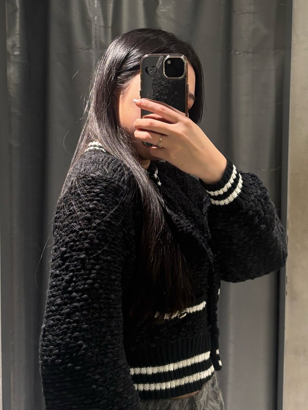 ブラック系のブーツ、ブラック系のカーディガン/ボレロ、グレー系のその他パンツを着用したレディースの冬コーディネートの4枚目の写真