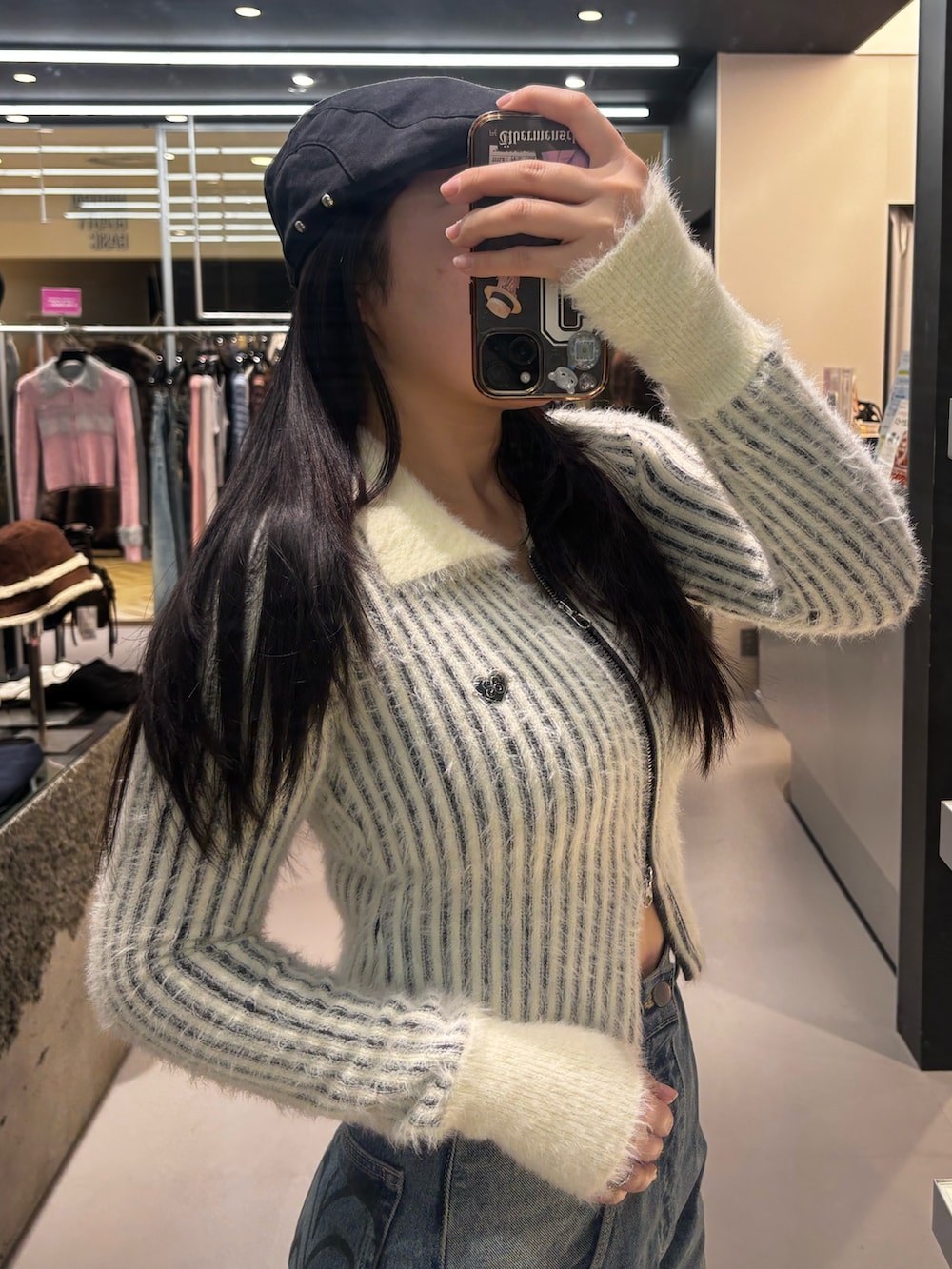 ブルー系のデニムパンツ、ブラック系のニット/セーター、ブラック系のブーツを着用したレディースの冬コーディネートの4枚目の写真