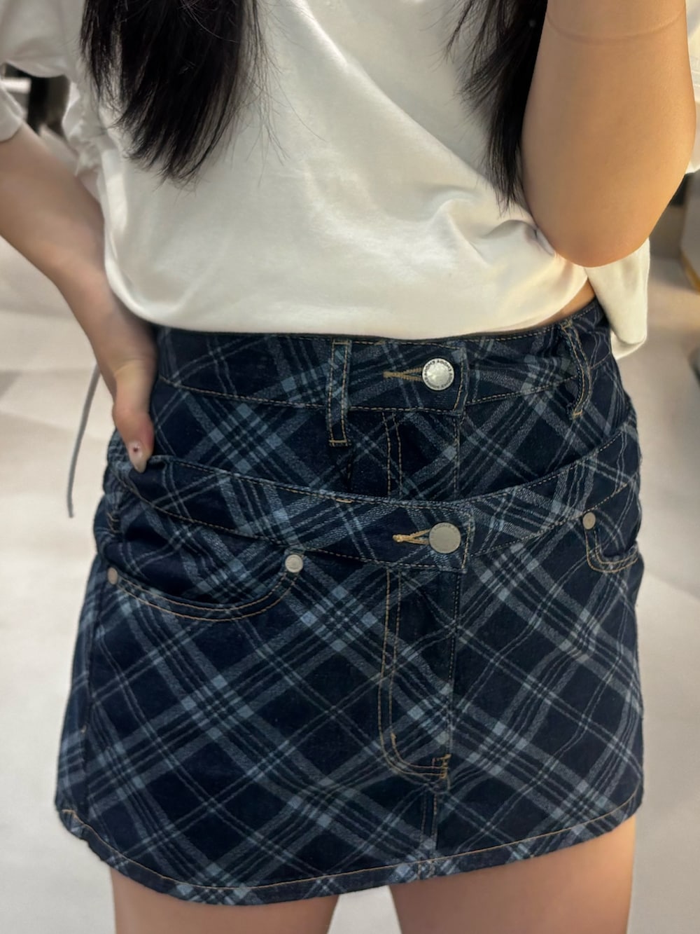 ブラック系のスニーカー、ホワイト系のTシャツ/カットソー、ブルー系のスカートを着用したレディースの春コーディネートの5枚目の写真