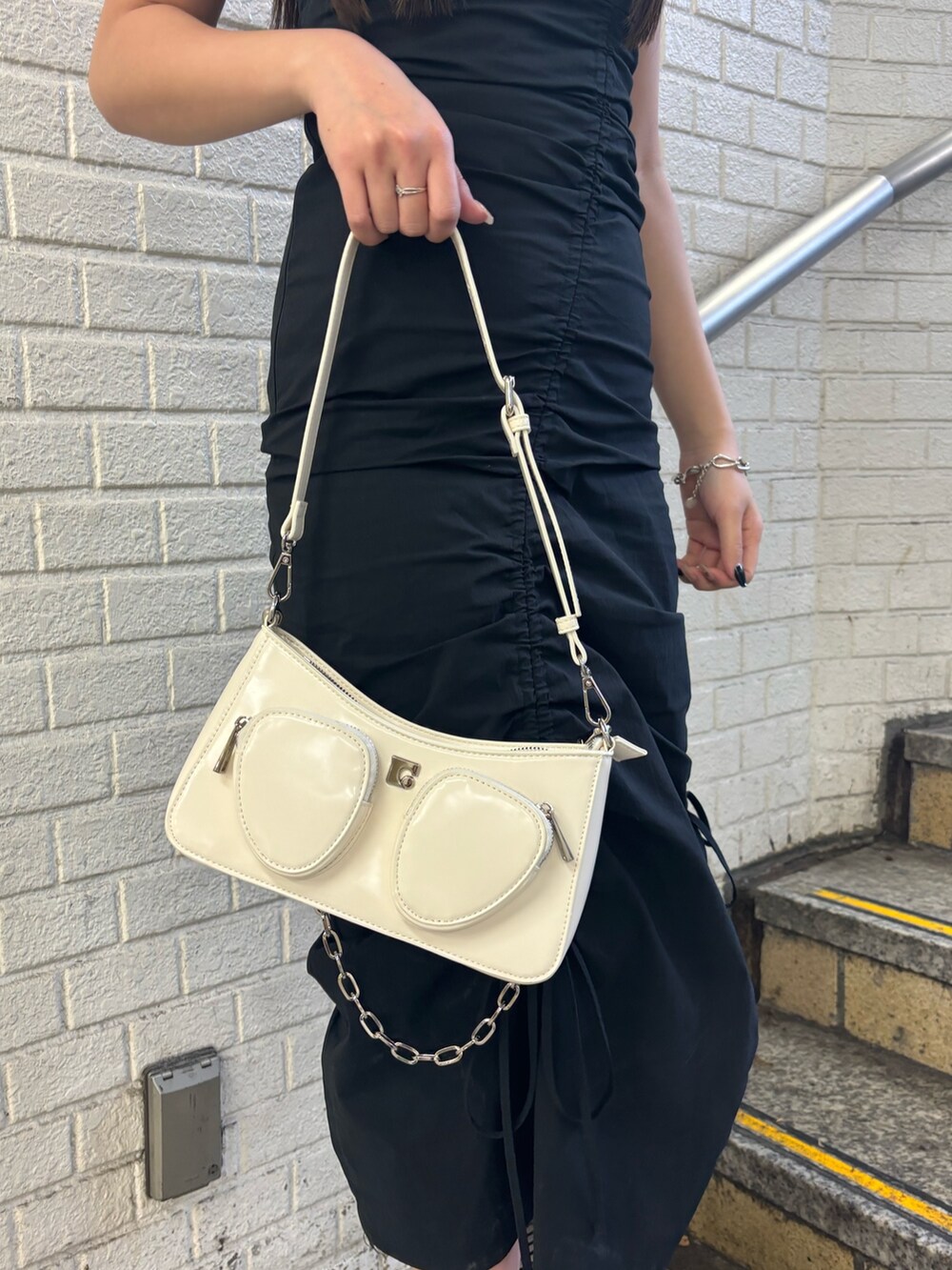 ブラック系のサンダル、ホワイト系のショルダーバッグ、ホワイト系のTシャツ/カットソーを着用したレディースの春コーディネートの5枚目の写真