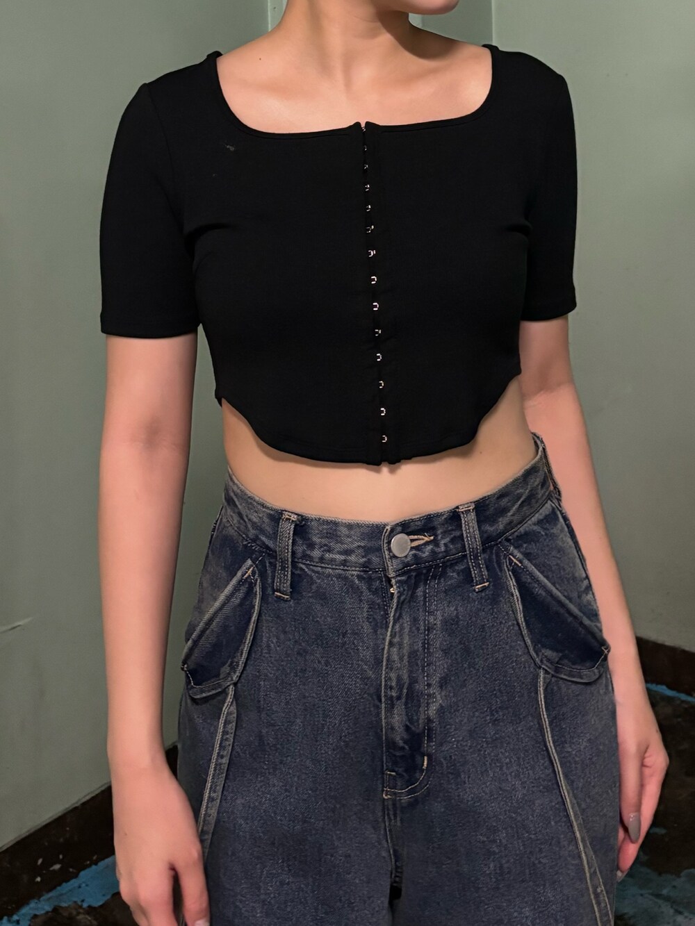 ブルー系のデニムパンツ、ブラック系のTシャツ/カットソー、ブラック系のサンダルを着用したレディースの夏コーディネートの4枚目の写真