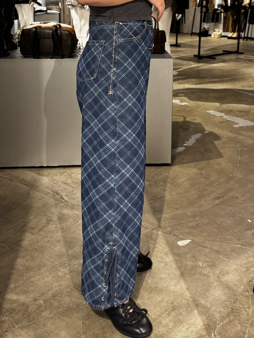 ブラック系のスニーカー、ブルー系のデニムパンツを着用したレディースの冬コーディネートの4枚目の写真