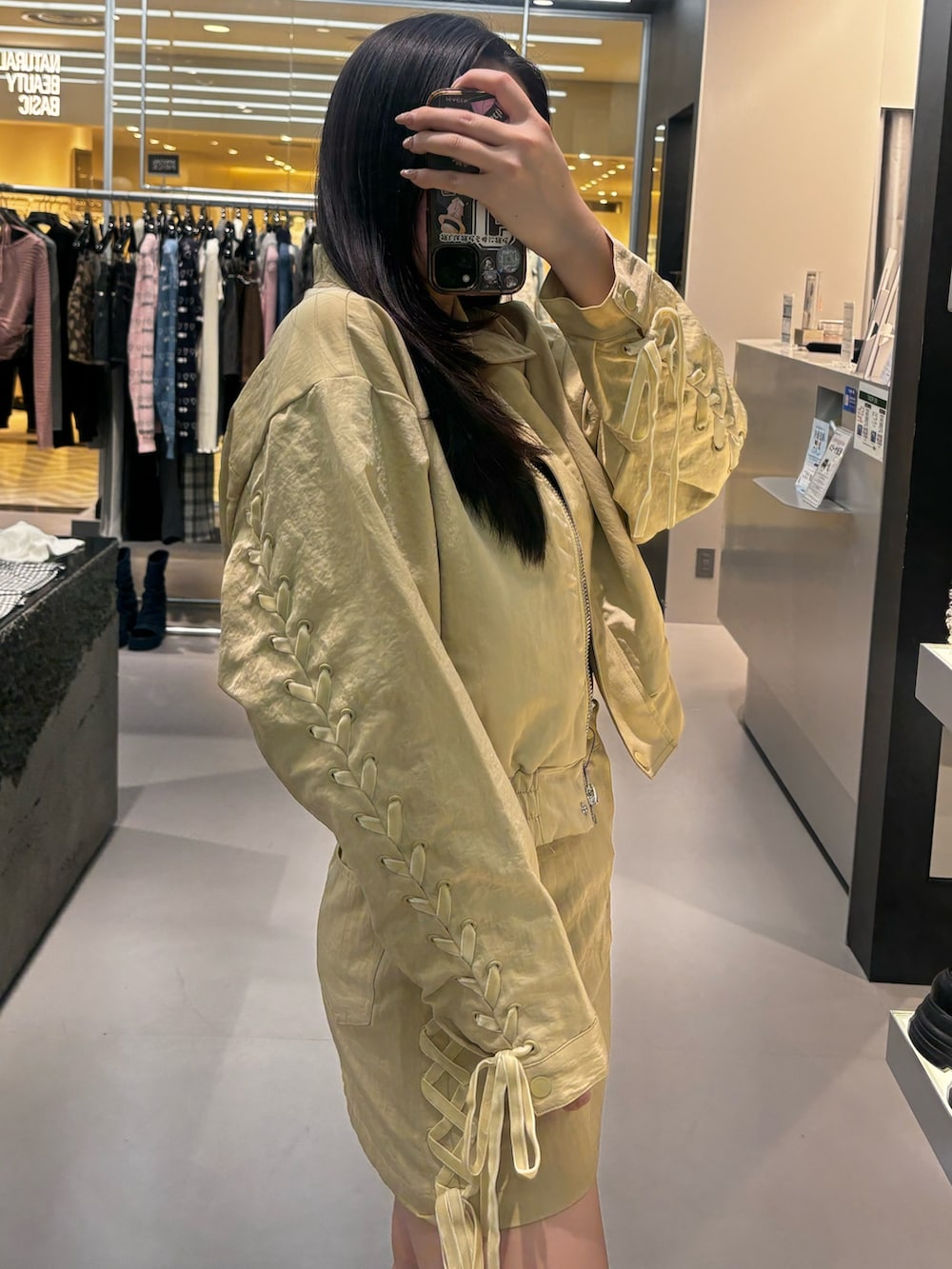 ブラック系のブーツ、イエロー系のスカート、イエロー系のブルゾンを着用したレディースの冬コーディネートの4枚目の写真