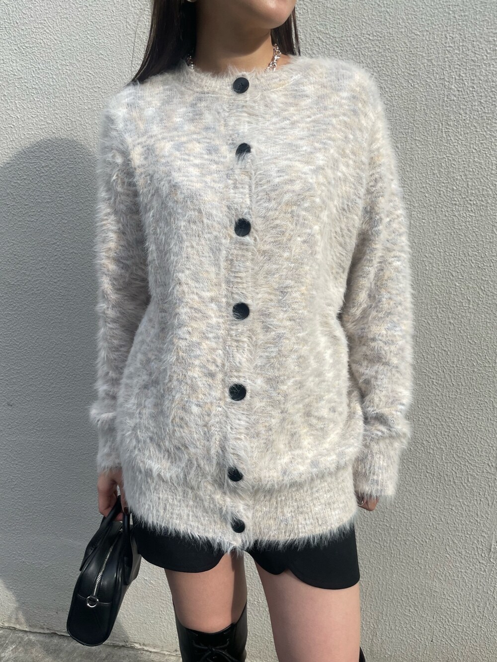 ブラック系のチェスターコート、その他のカーディガン/ボレロ、ブラック系のブーツを着用したレディースの冬コーディネートの7枚目の写真