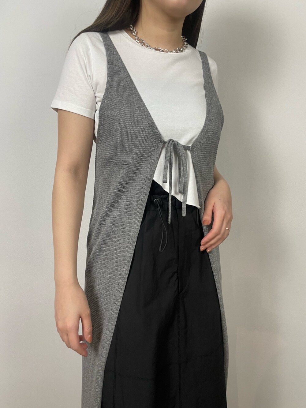 ブラック系のスカート、ホワイト系のTシャツ/カットソー、ブラック系のサンダルを着用したレディースの夏コーディネートの8枚目の写真