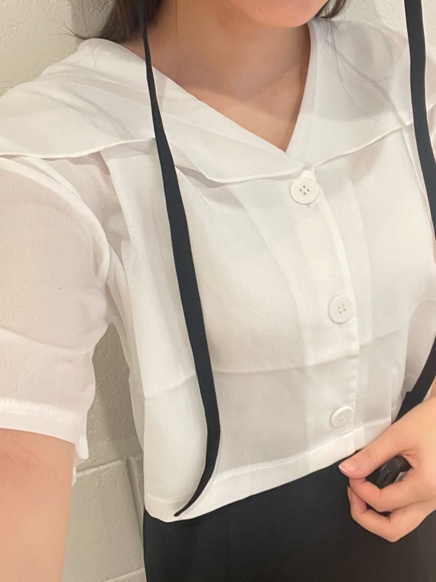 ホワイト系のシャツ/ブラウス、ブラック系のスカート、ブラック系のサンダルを着用したレディースの夏コーディネートの6枚目の写真