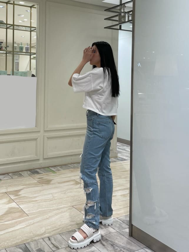 ホワイト系のサンダル、ブルー系のデニムパンツ、ホワイト系のTシャツ/カットソーを着用したレディースの夏コーディネートの2枚目の写真