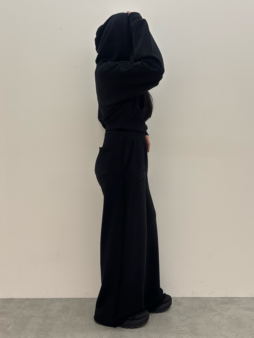 ブラック系のスニーカー、ブラック系のスウェットパンツ、ブラック系のパーカーを着用したレディースの夏コーディネートの2枚目の写真