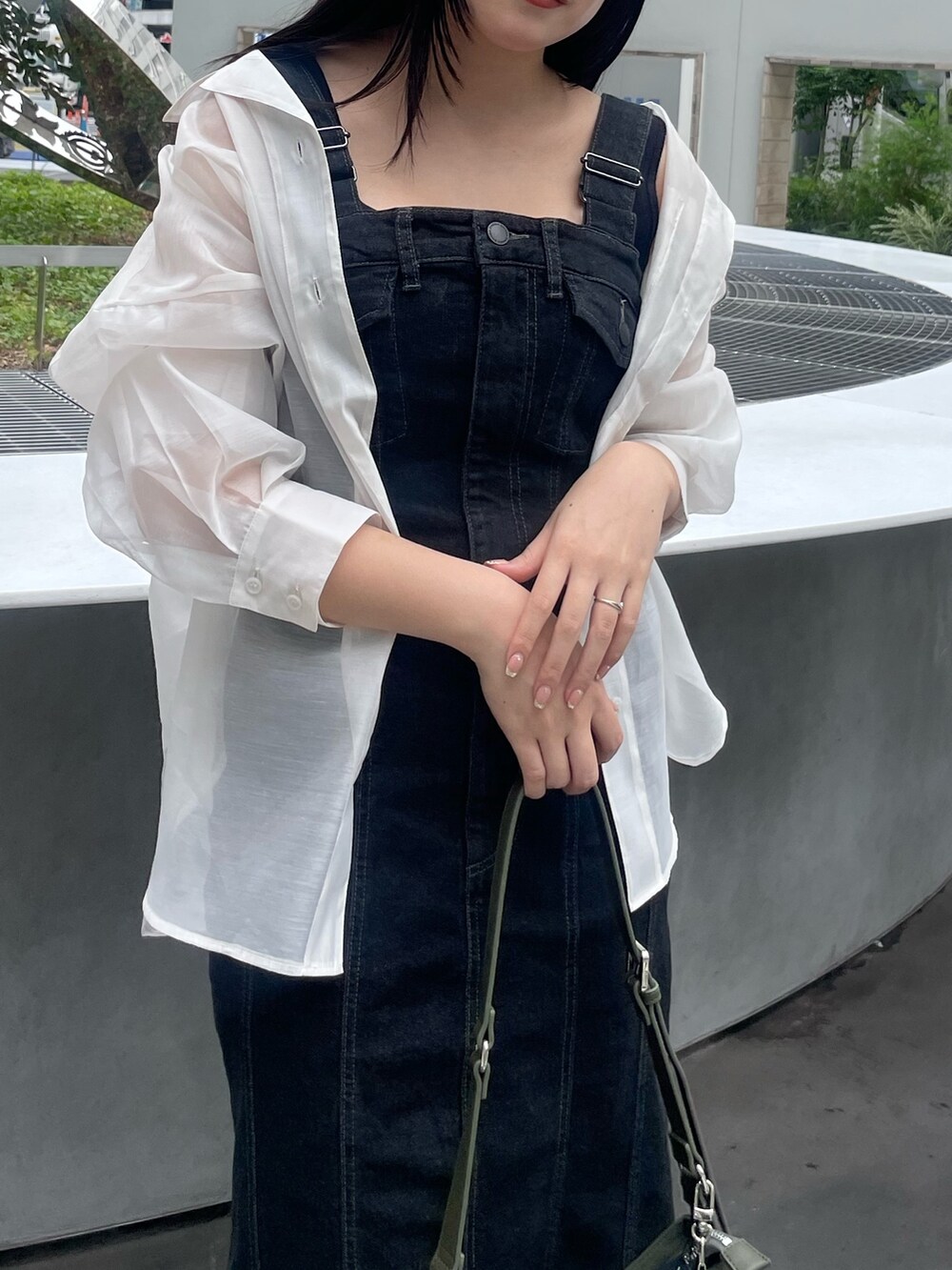 ブラック系のワンピース、ホワイト系のシャツ/ブラウス、ブラック系のサンダルを着用したレディースの夏コーディネートの3枚目の写真