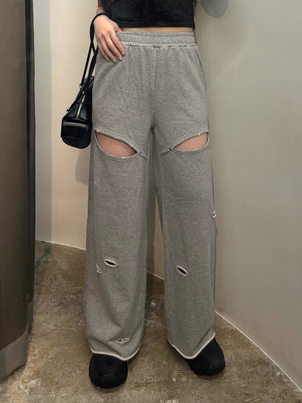 ブラック系のスニーカー、ブラック系のハンドバッグ、ブラック系のTシャツ/カットソーを着用したレディースの夏コーディネートの4枚目の写真