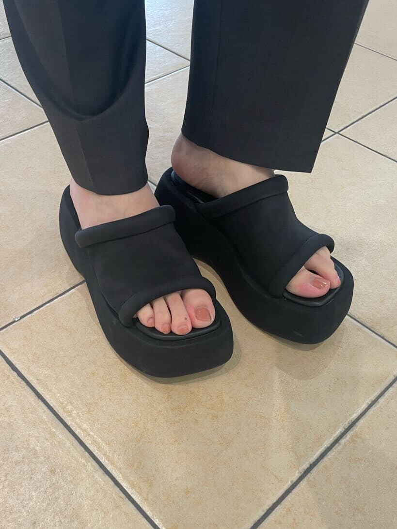 ブラック系のサンダル、ホワイト系のTシャツ/カットソー、ブラック系のベストを着用したレディースの夏コーディネートの7枚目の写真