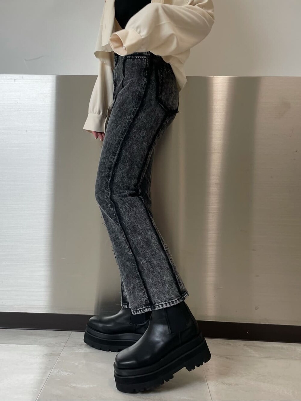 ブラック系のデニムパンツ、ホワイト系のテーラードジャケット、ブラック系のTシャツ/カットソーを着用したレディースの秋コーディネートの5枚目の写真