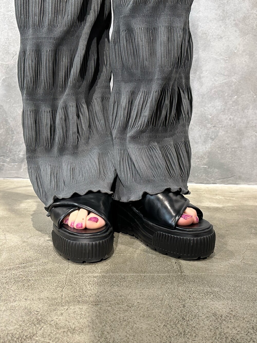 グレー系のその他パンツ、ブラック系のベスト、ブルー系のキャミソールを着用したレディースの春コーディネートの6枚目の写真