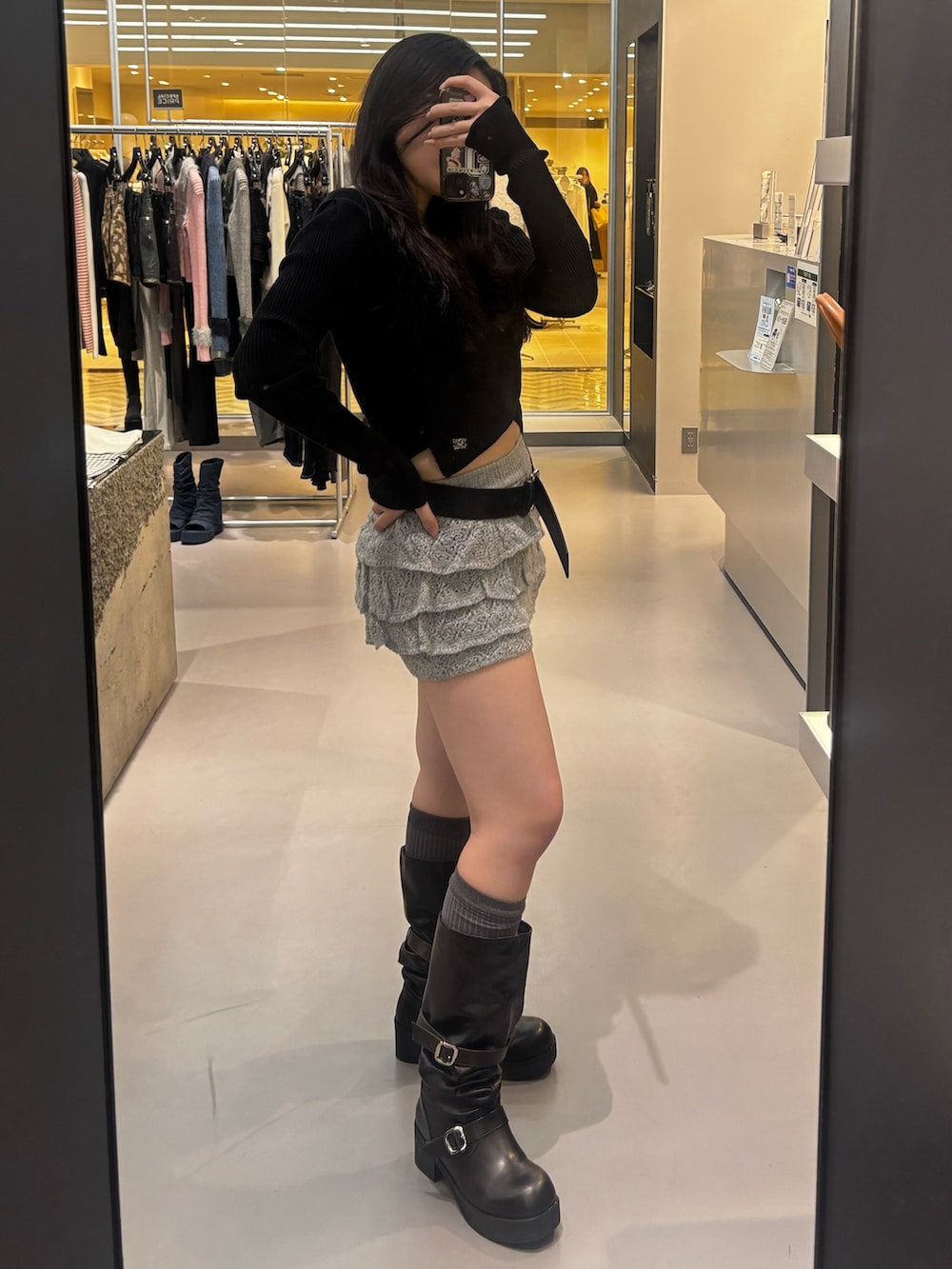 ブラック系のブーツ、グレー系のスカート、ブラック系のニット/セーターを着用したレディースの冬コーディネートの2枚目の写真