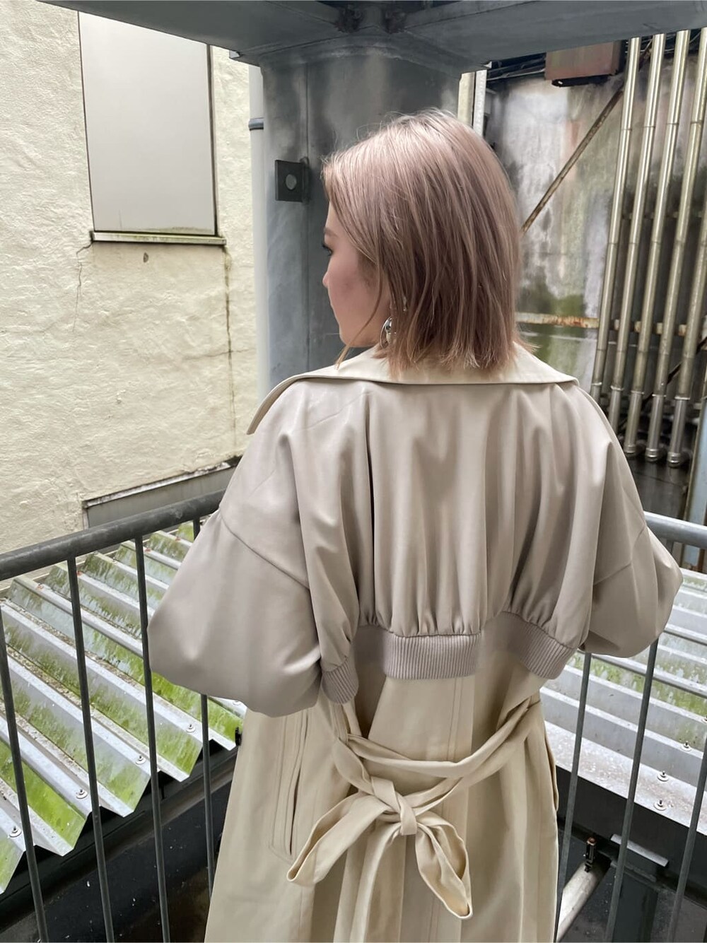 ブラック系のデニムパンツ、ホワイト系のトレンチコート、その他のブーツを着用したレディースの秋コーディネートの5枚目の写真