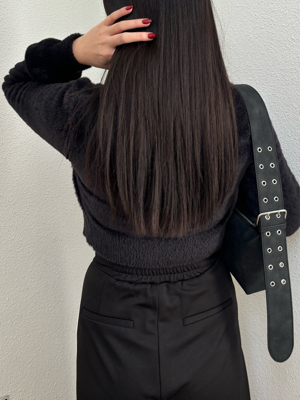 ブラック系のスラックス、ブラック系のニット/セーター、ブラック系のスニーカーを着用したレディースの冬コーディネートの4枚目の写真