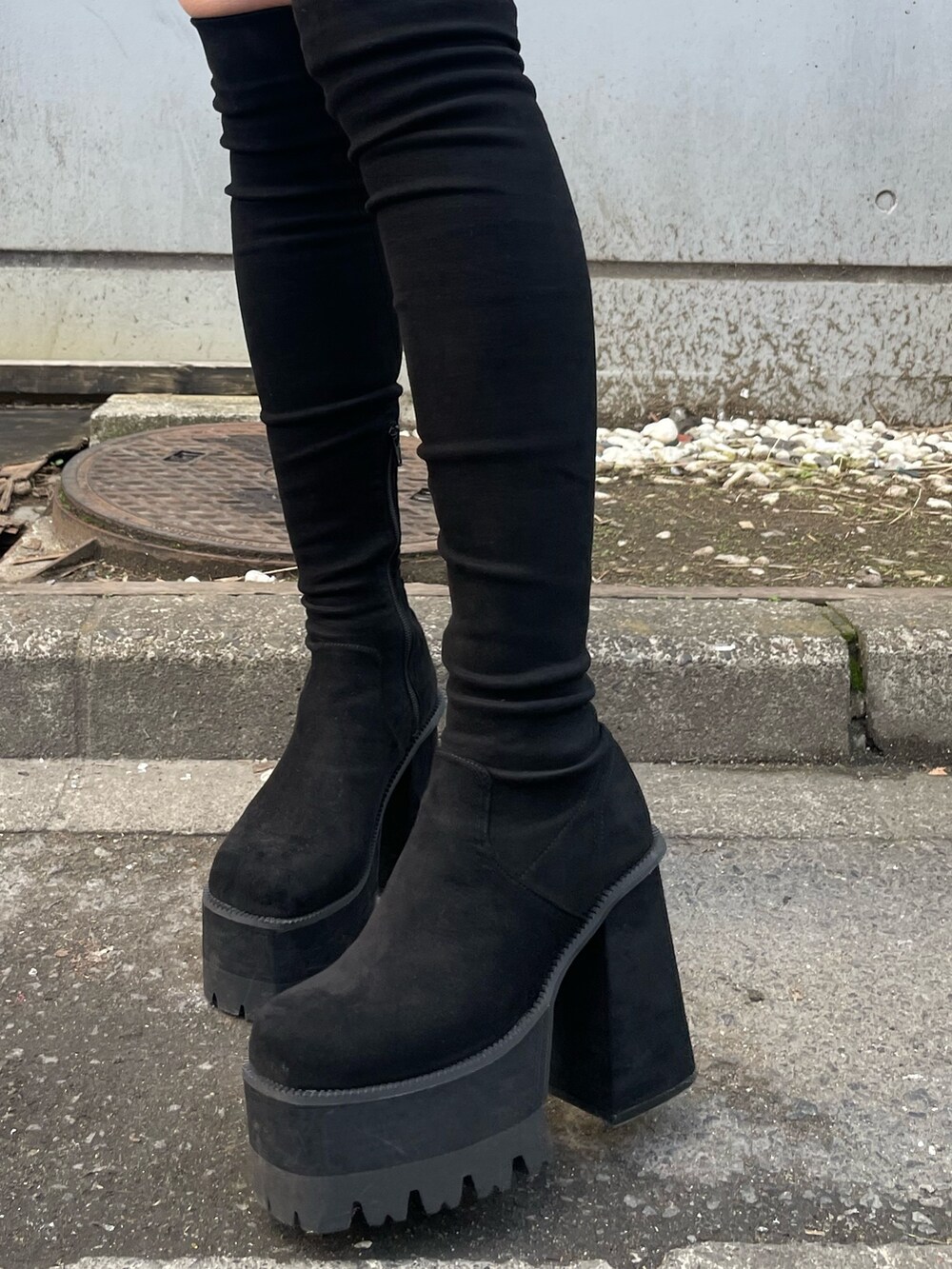 ブラック系のニット/セーター、ブラック系のスカート、ブラック系のブーツを着用したレディースの冬コーディネートの7枚目の写真