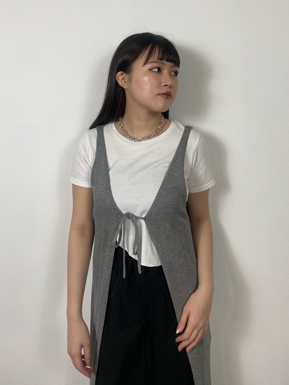 ブラック系のスカート、ホワイト系のTシャツ/カットソー、ブラック系のサンダルを着用したレディースの夏コーディネートの4枚目の写真