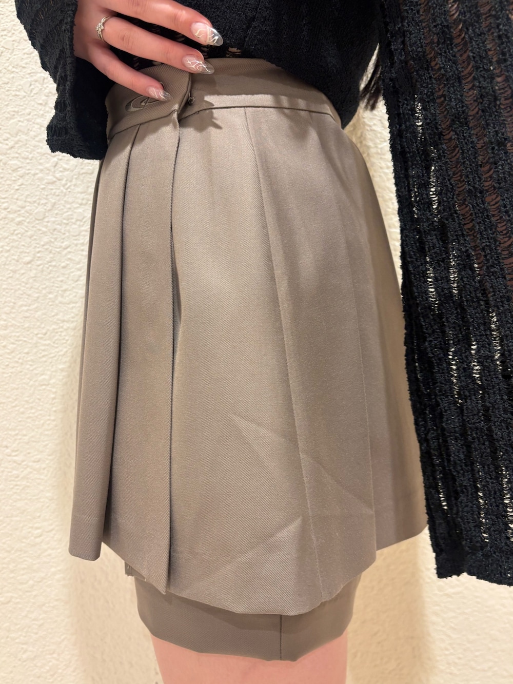 ブラック系のサンダル、ベージュ系のスカート、ブラック系のニット/セーターを着用したレディースの春コーディネートの8枚目の写真