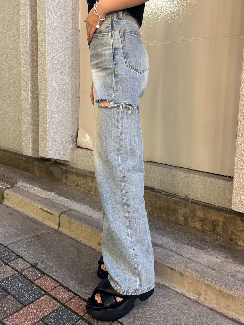 ホワイト系のデニムパンツ、ブラック系のニット/セーター、ブラック系のサンダルを着用したレディースの夏コーディネートの8枚目の写真