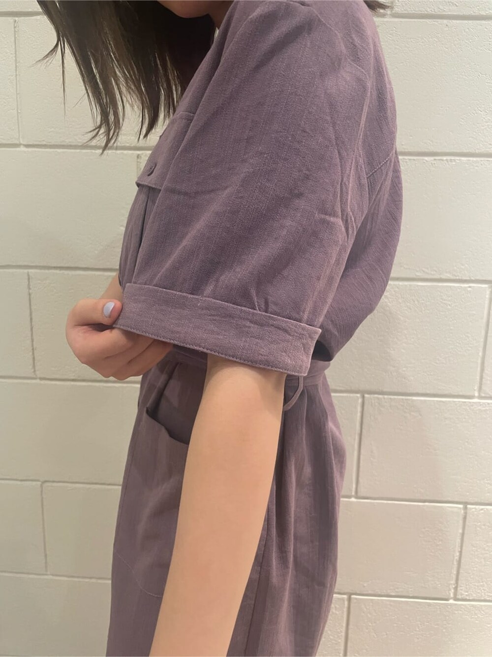 ブラック系のハンドバッグ、ブラック系のサンダル、パープル系のワンピースを着用したレディースの春コーディネートの6枚目の写真