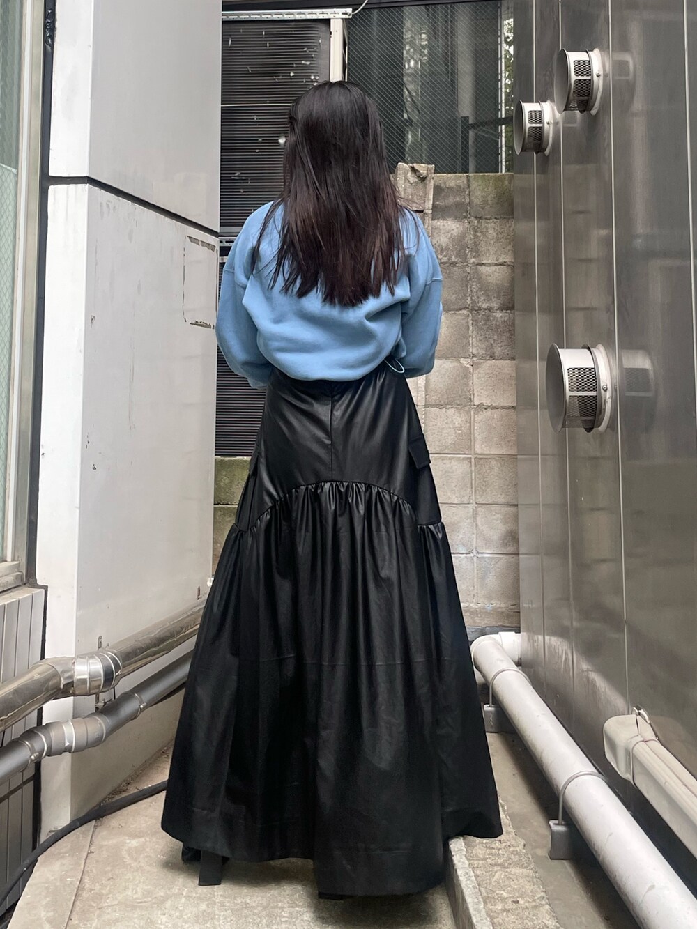 ブラック系のブーツ、ブラック系のスカート、ブルー系のスウェットを着用したレディースの秋コーディネートの3枚目の写真