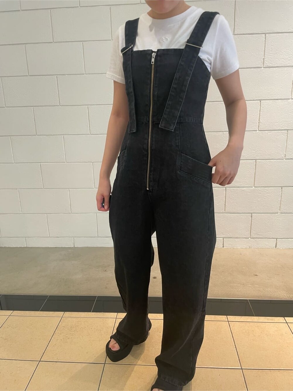 ブラック系のサンダル、ブラック系のつなぎ/オールインワン、ホワイト系のTシャツ/カットソーを着用したレディースの夏コーディネートの4枚目の写真