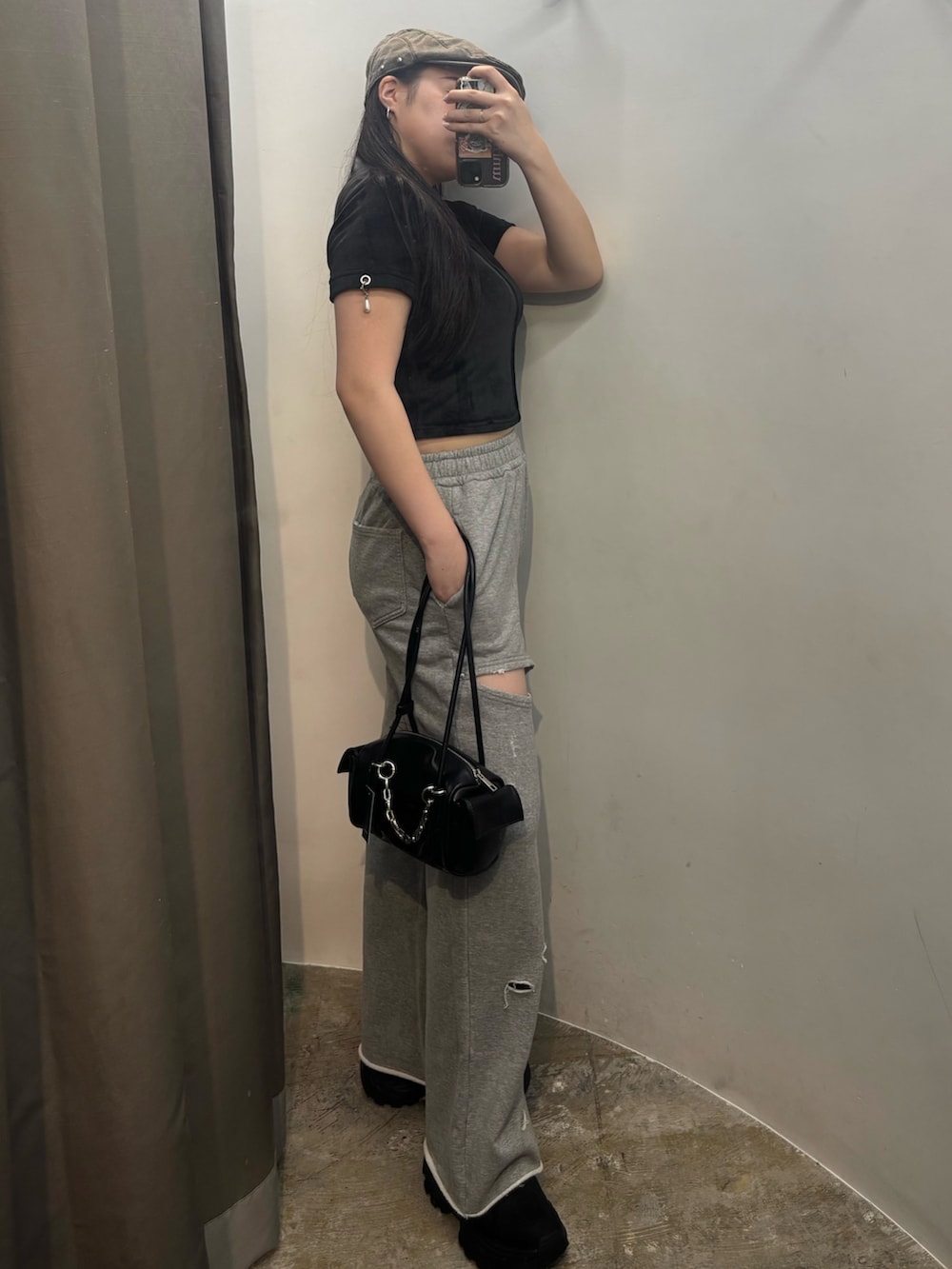 ブラック系のスニーカー、ブラック系のハンドバッグ、ブラック系のTシャツ/カットソーを着用したレディースの夏コーディネートの2枚目の写真
