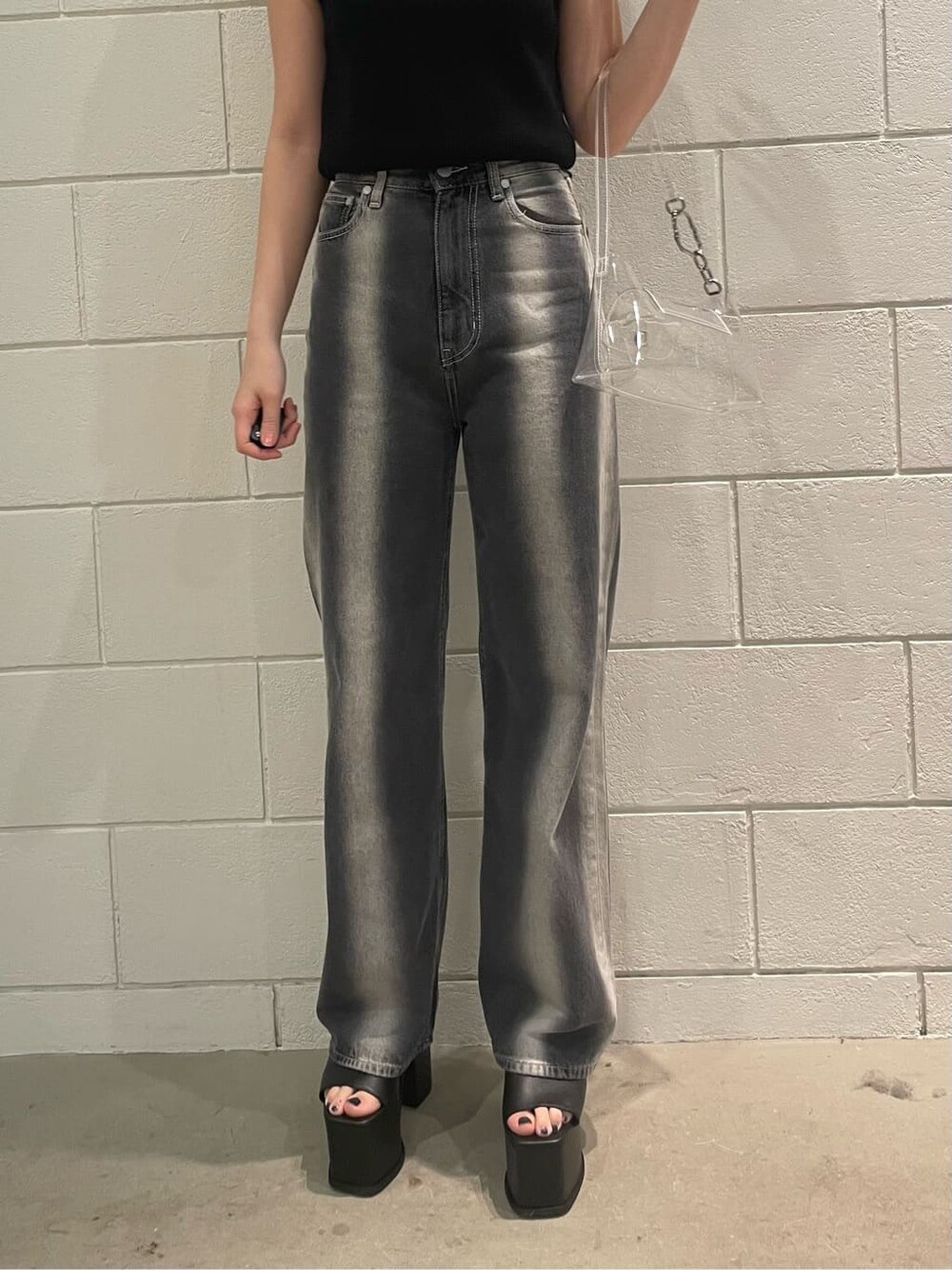 ブラック系のサンダル、ブラック系のタンクトップ、ブラック系のデニムパンツを着用したレディースの春コーディネートの5枚目の写真