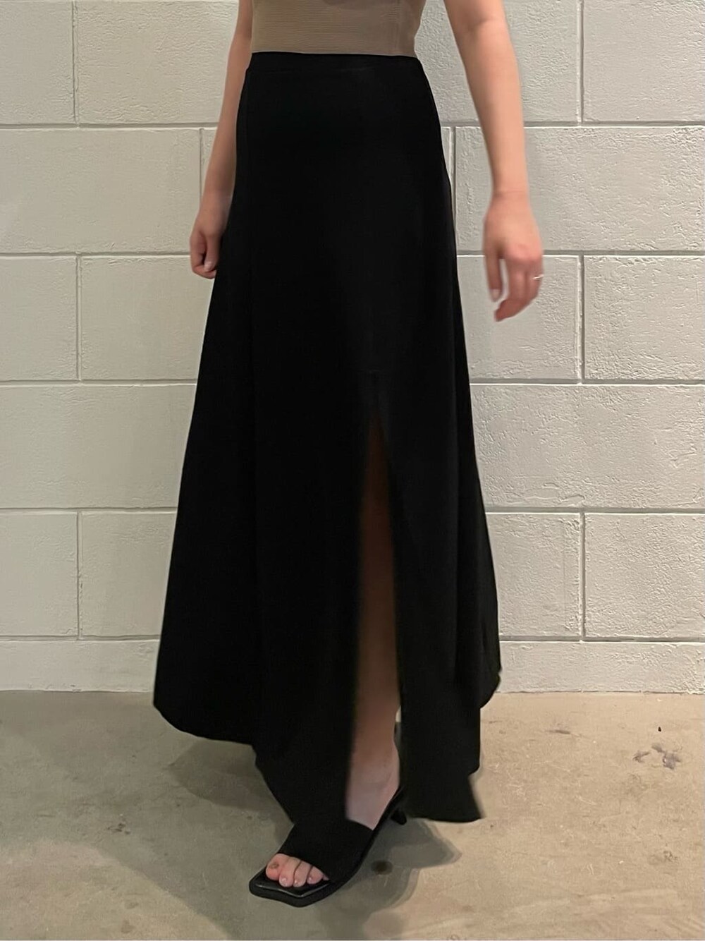 ベージュ系のニット/セーター、ブラック系のスカート、ブラック系のサンダルを着用したレディースの夏コーディネートの6枚目の写真