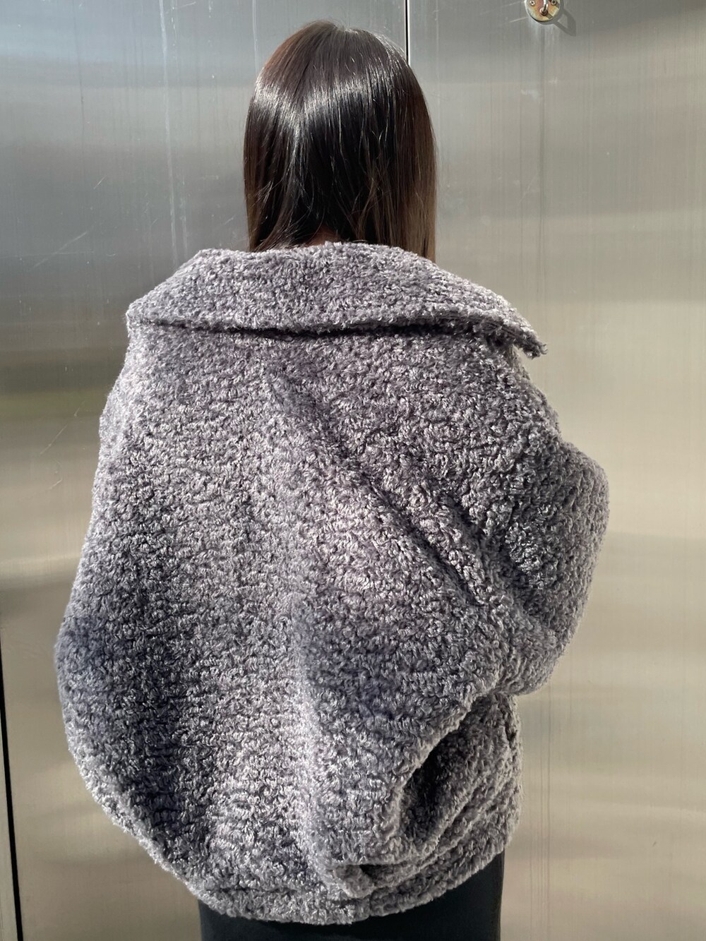 グレー系のブルゾン、ブラック系のワンピース、ブラック系のブーツを着用したレディースの冬コーディネートの6枚目の写真