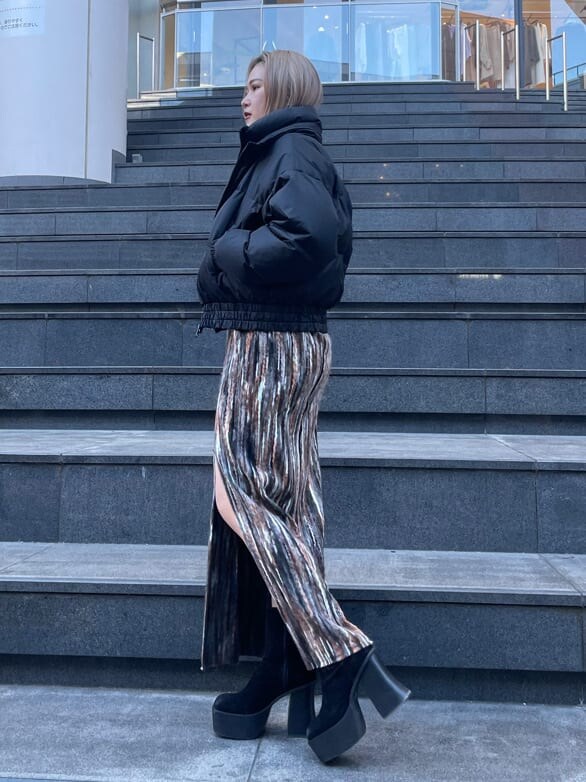 ブラック系のブーツ、ブラック系のダウンジャケット/コート、ブラウン系のスカートを着用したレディースの冬コーディネートの2枚目の写真