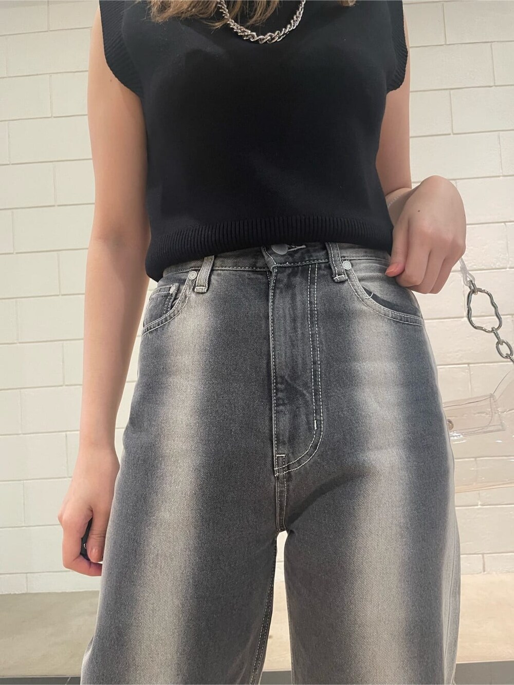 ブラック系のサンダル、ブラック系のタンクトップ、ブラック系のデニムパンツを着用したレディースの春コーディネートの4枚目の写真