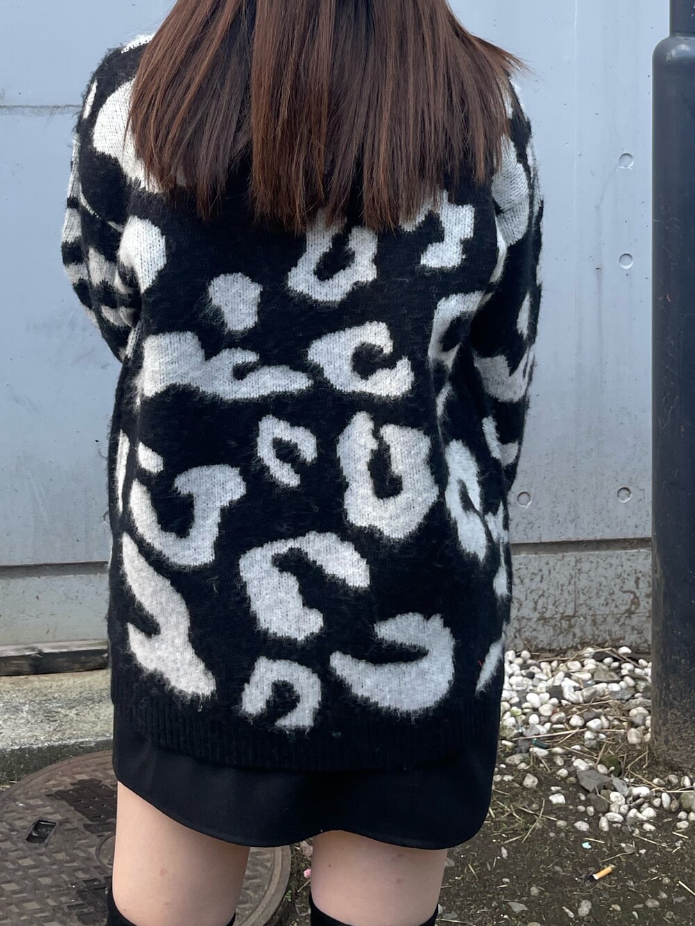 ブラック系のニット/セーター、ブラック系のスカート、ブラック系のブーツを着用したレディースの冬コーディネートの5枚目の写真