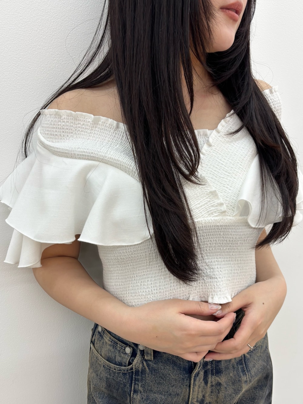 ブラック系のサンダル、ブルー系のデニムパンツを着用したレディースの春コーディネートの4枚目の写真