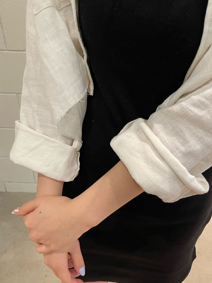 ブラック系のワンピース、ホワイト系のブルゾン、ブラック系のサンダルを着用したレディースの春コーディネートの7枚目の写真