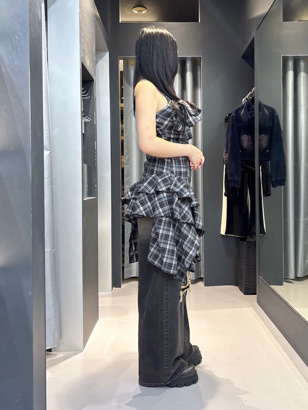 ブラック系のブーツ、ブラック系のデニムパンツ、ブラック系のワンピースを着用したレディースの夏コーディネートの2枚目の写真