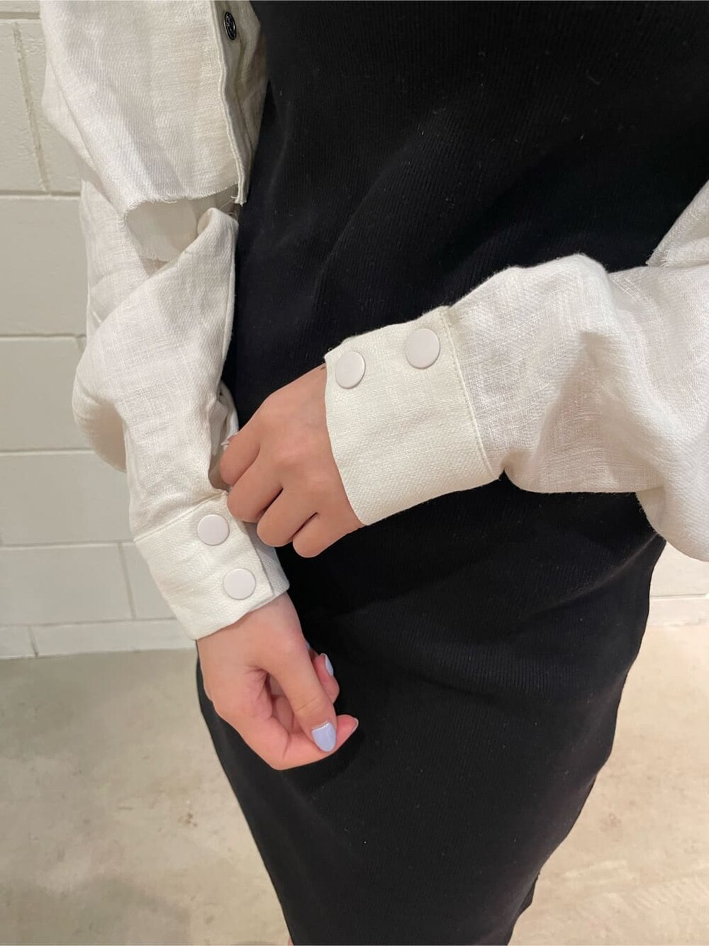 ブラック系のワンピース、ホワイト系のブルゾン、ブラック系のサンダルを着用したレディースの春コーディネートの8枚目の写真