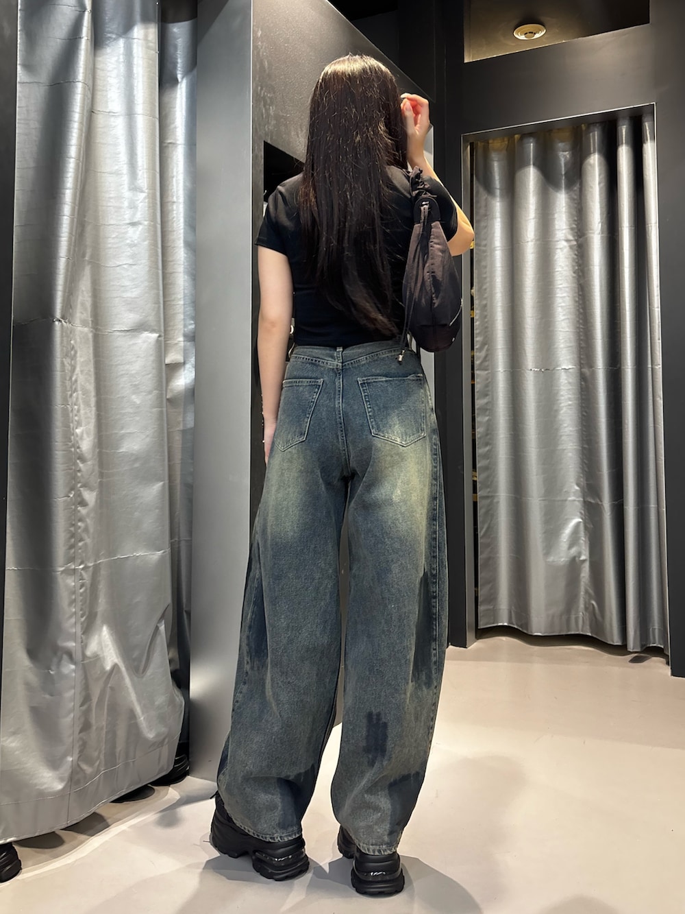 ブラック系のスニーカー、ブルー系のデニムパンツ、ブラック系のTシャツ/カットソーを着用したレディースの夏コーディネートの3枚目の写真