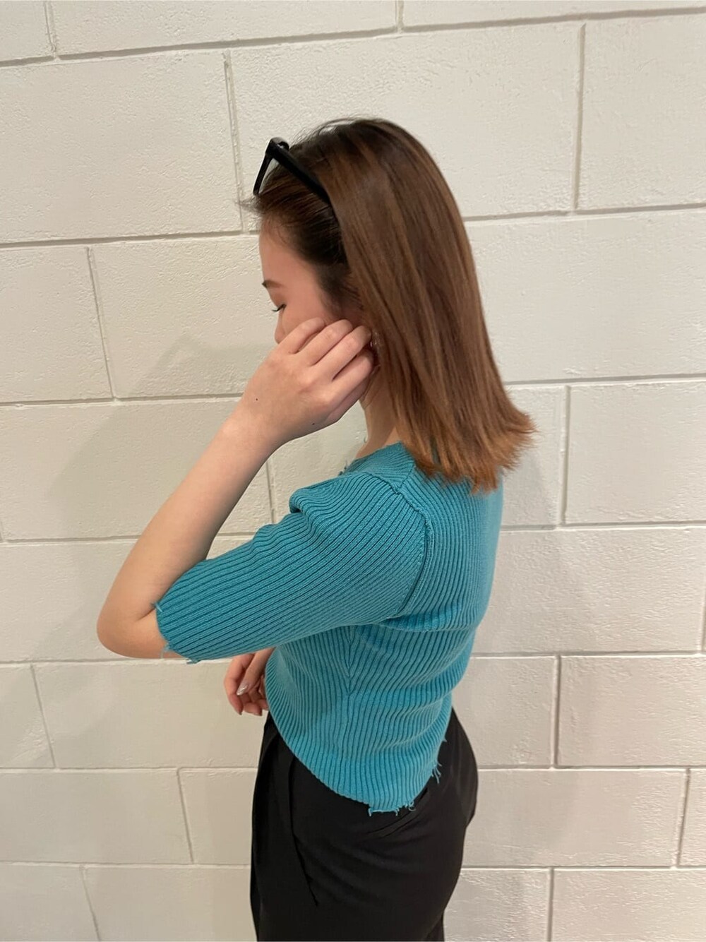 ブラック系のサンダル、ブラック系のスラックス、ブルー系のニット/セーターを着用したレディースの春コーディネートの4枚目の写真