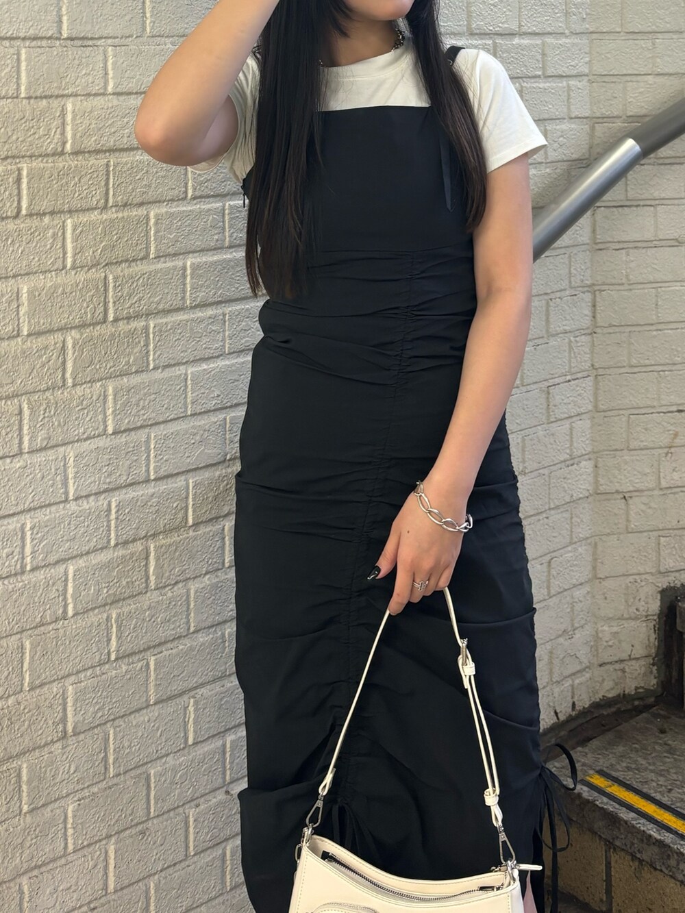 ブラック系のサンダル、ホワイト系のショルダーバッグ、ホワイト系のTシャツ/カットソーを着用したレディースの春コーディネートの4枚目の写真