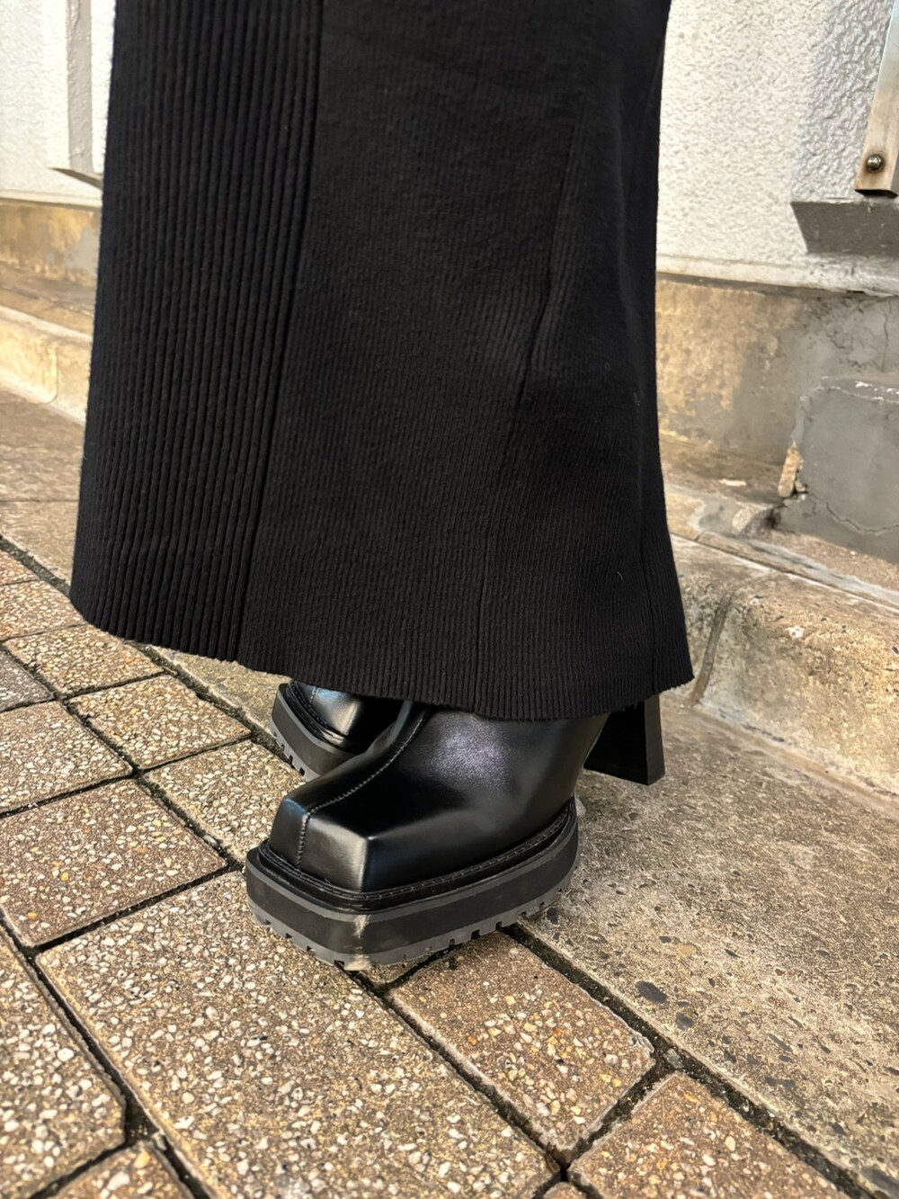 ブラック系のワンピース、ブラック系のブーツ、シルバー系のハンドバッグを着用したレディースの秋コーディネートの7枚目の写真