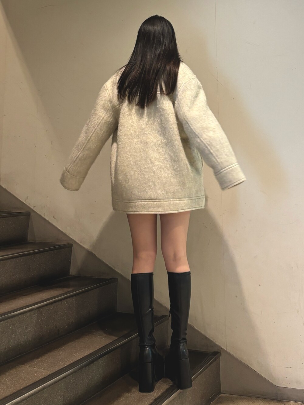 その他のブーツ、ホワイト系のピーコート、グレー系のニット/セーターを着用したレディースの秋コーディネートの3枚目の写真