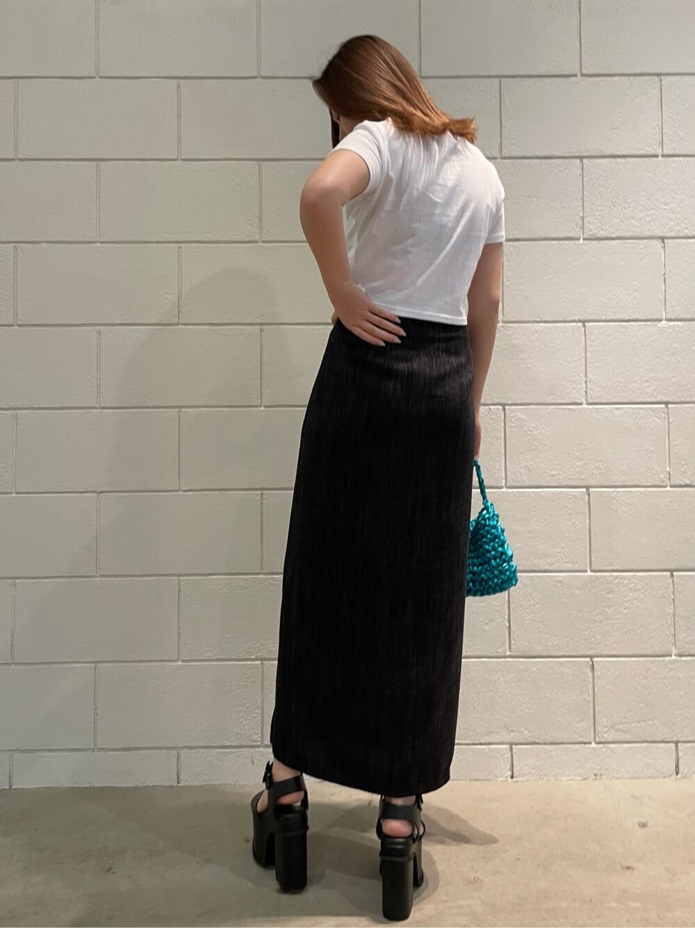 ブラック系のサンダル、ブラック系のスカート、ブルー系のハンドバッグを着用したレディースの春コーディネートの2枚目の写真