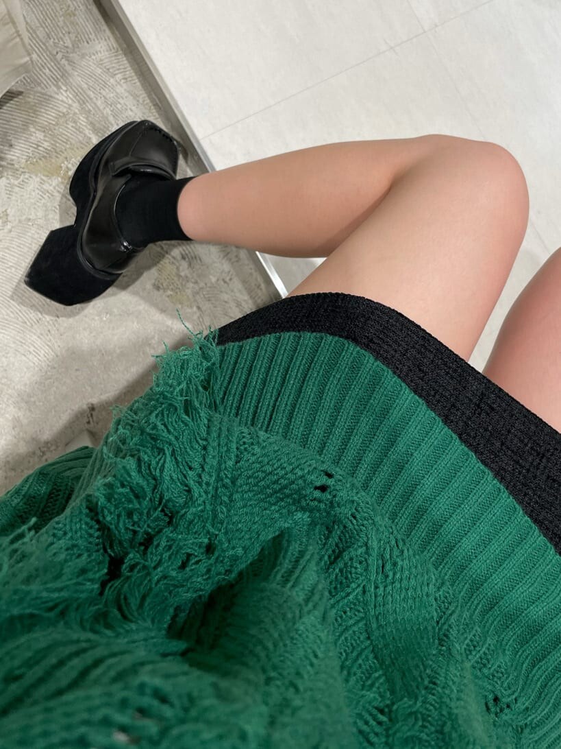 ブラック系のスカート、ブラック系のローファー、グリーン系のニット/セーターを着用したレディースの秋コーディネートの5枚目の写真